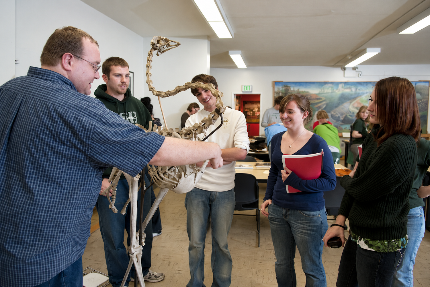 Person showing a group of students an animal skeleton specimen during a hands-on university learning activity.