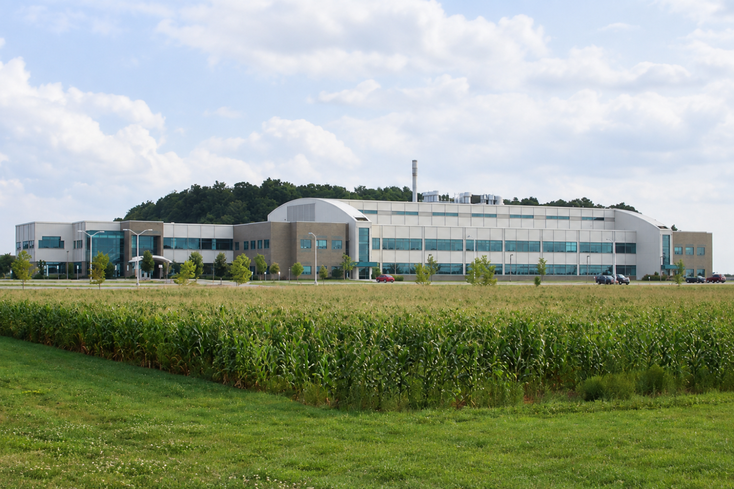 Michigan State University Veterinary Diagnostic Laboratory building viewed across a cornfield and grassy landscape.