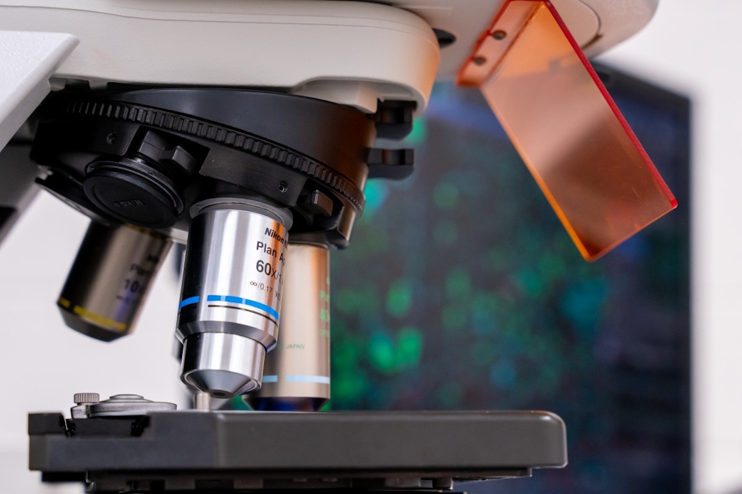 Microscope objectives with a blurred computer screen in the background